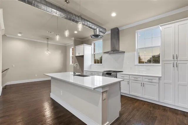 a kitchen with stainless steel appliances wooden floor and large window