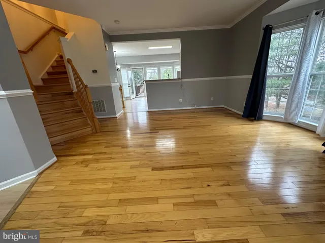 a view of empty room with wooden floor