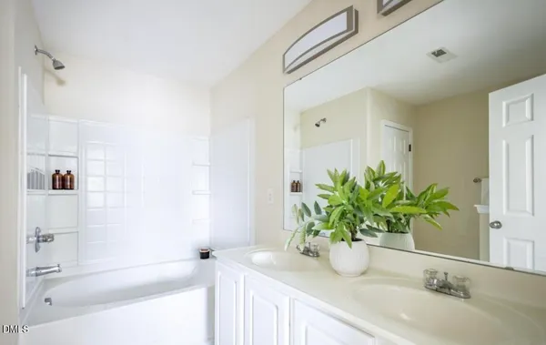 a bathroom with a granite countertop sink a mirror and a shower