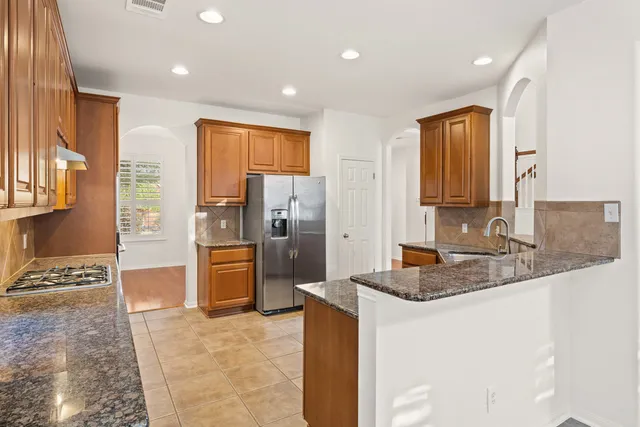 a kitchen with stainless steel appliances granite countertop a refrigerator and a sink