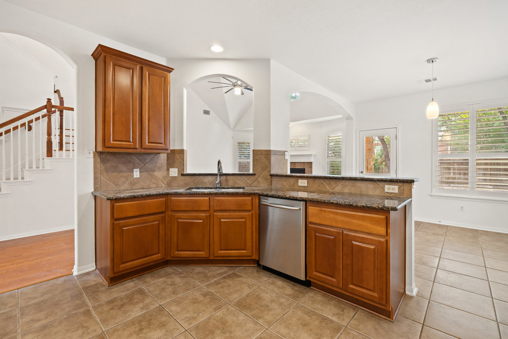 908 Golden Palomino Court Austin, TX 78732 - Photo 16 of 40 a kitchen with granite countertop a sink and cabinets