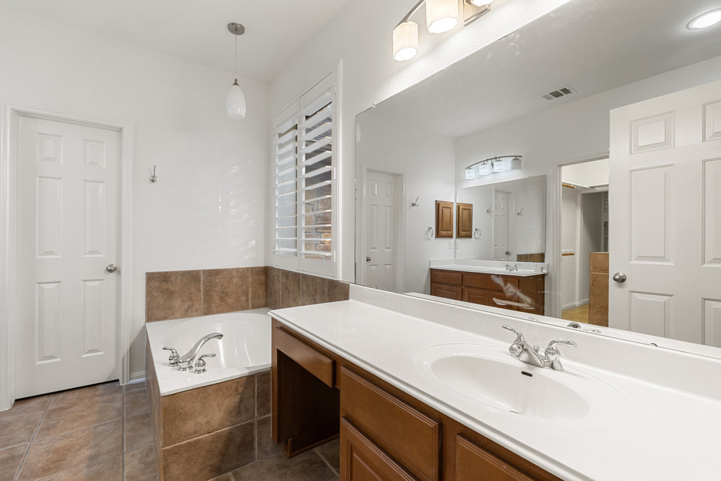 908 Golden Palomino Court Austin, TX 78732 - Photo 20 of 40 a bathroom with a sink a granite counter tops and a mirror