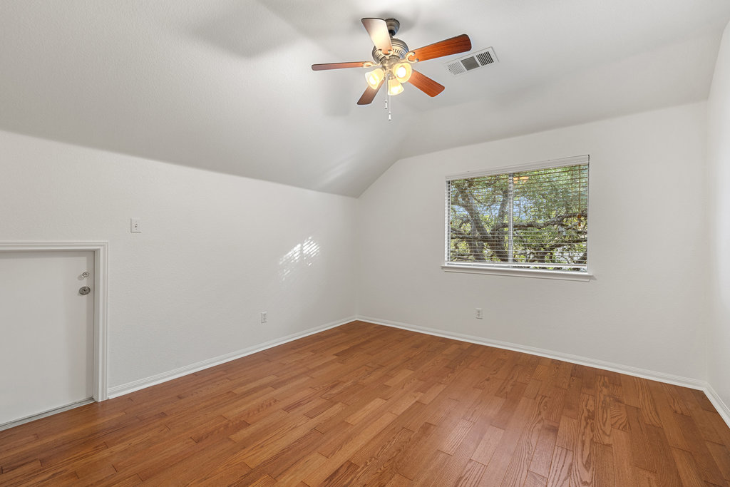 908 Golden Palomino Court Austin, TX 78732 - Photo 26 of 40 a view of a big room with wooden floor and a ceiling fan