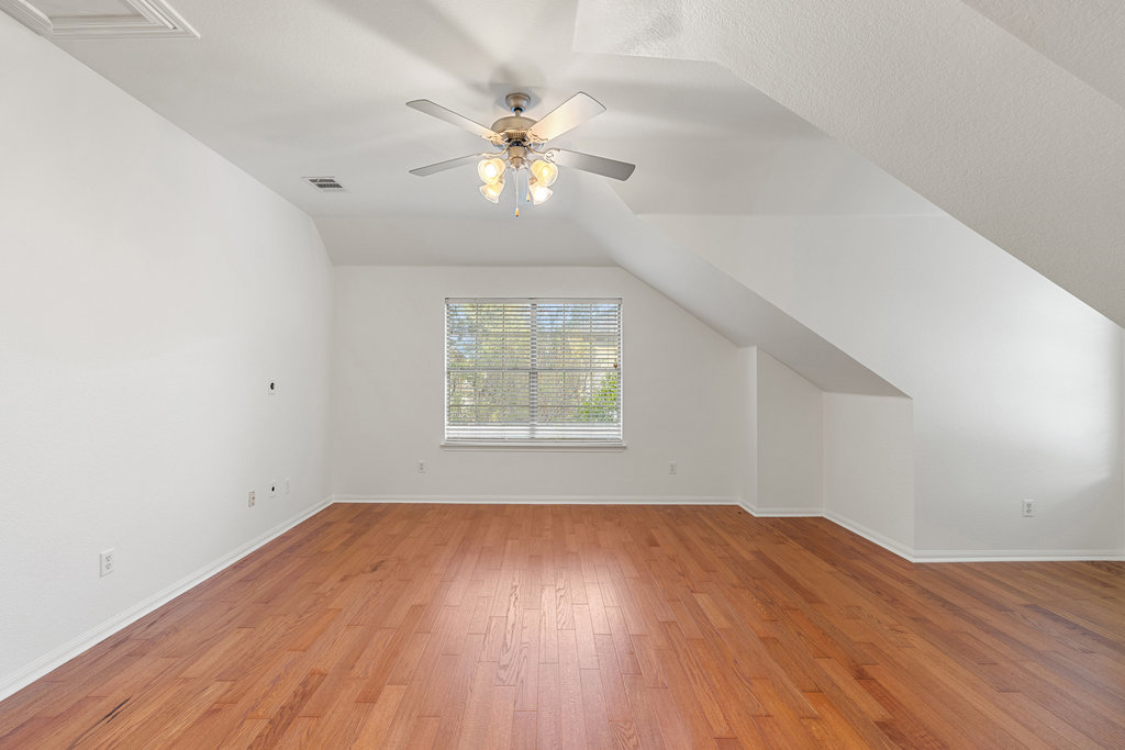 908 Golden Palomino Court Austin, TX 78732 - Photo 29 of 40 an empty room with wooden floor chandelier fan and windows