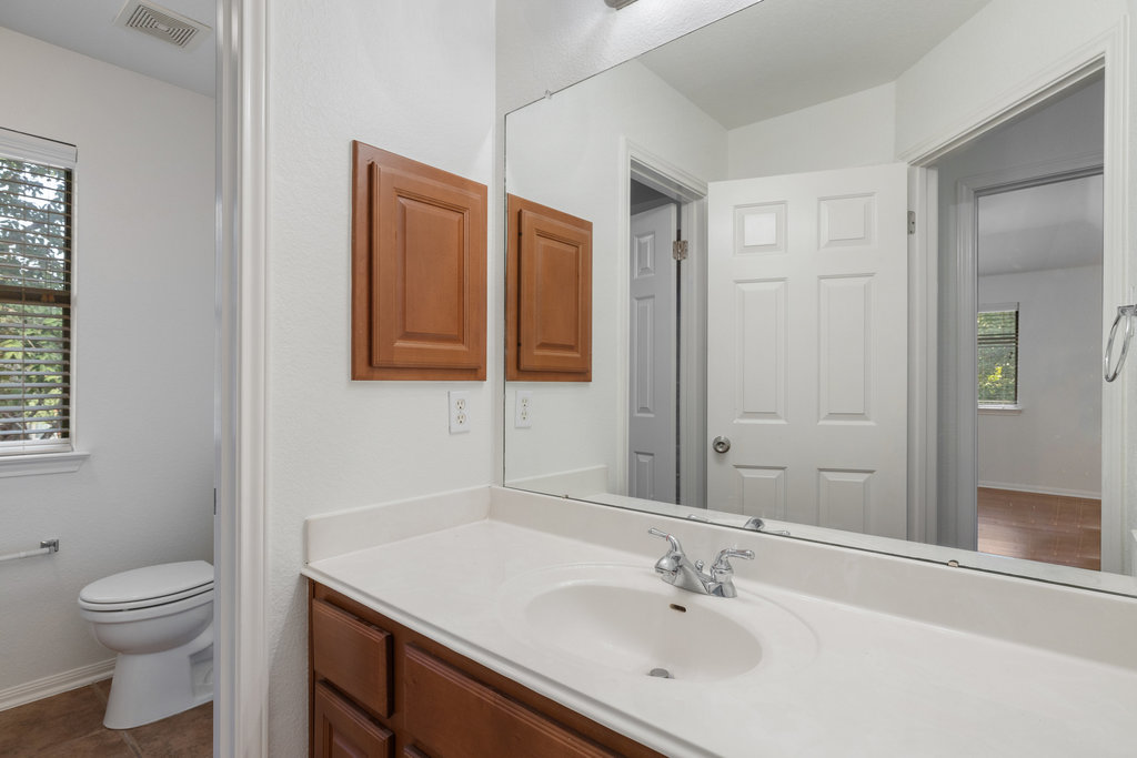 908 Golden Palomino Court Austin, TX 78732 - Photo 32 of 40 a bathroom with a granite countertop sink toilet and shower