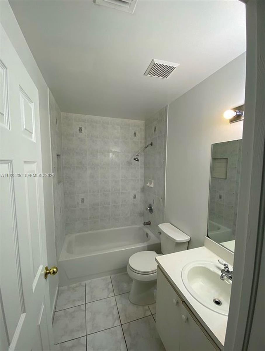 12035 Southwest 14th Street, Unit 103 Miami, FL 33184 - Photo 3 of 17 a bathroom with a sink a toilet and shower