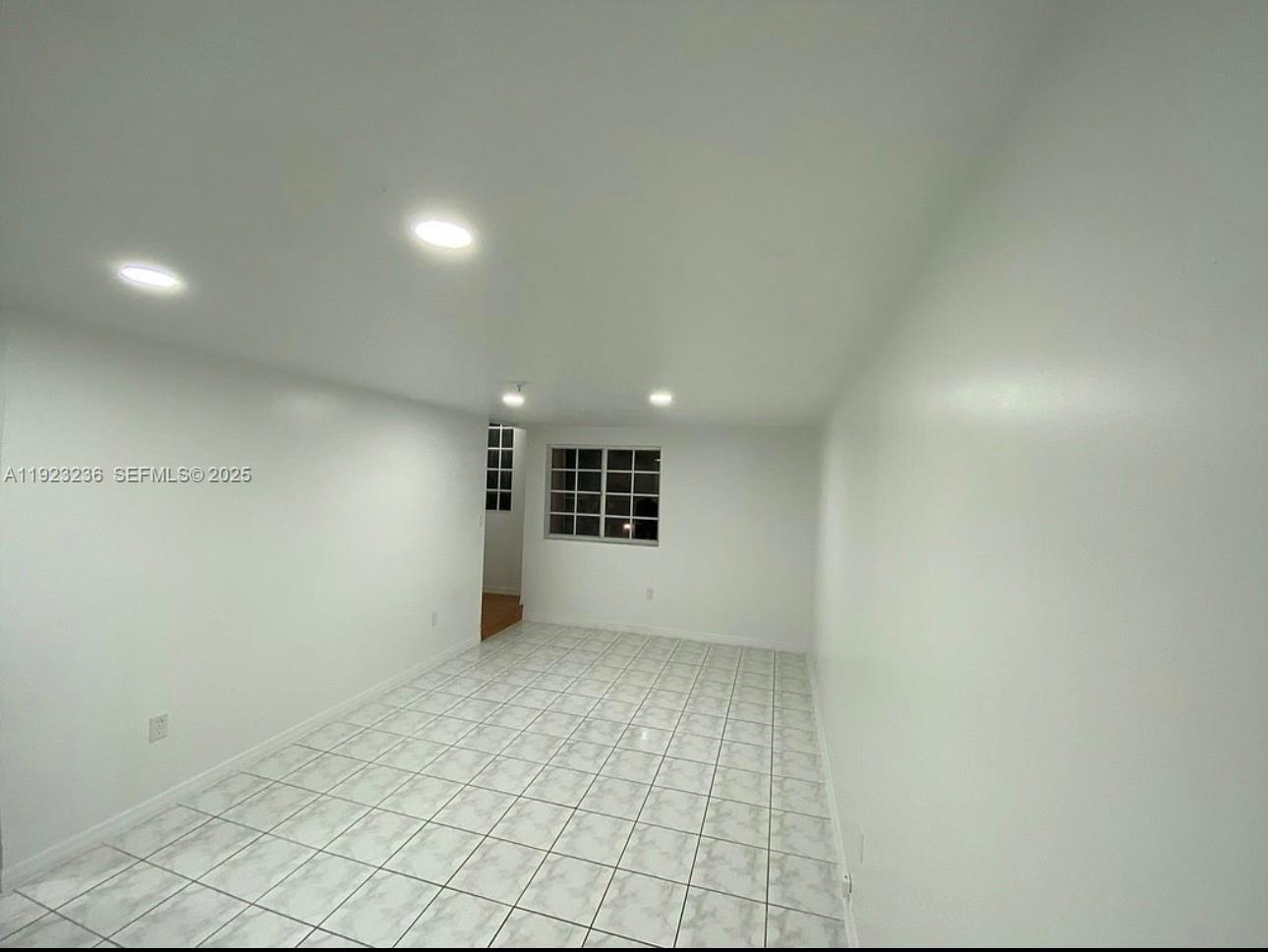 12035 Southwest 14th Street, Unit 103 Miami, FL 33184 - Photo 7 of 17 an empty room with a empty space and windows