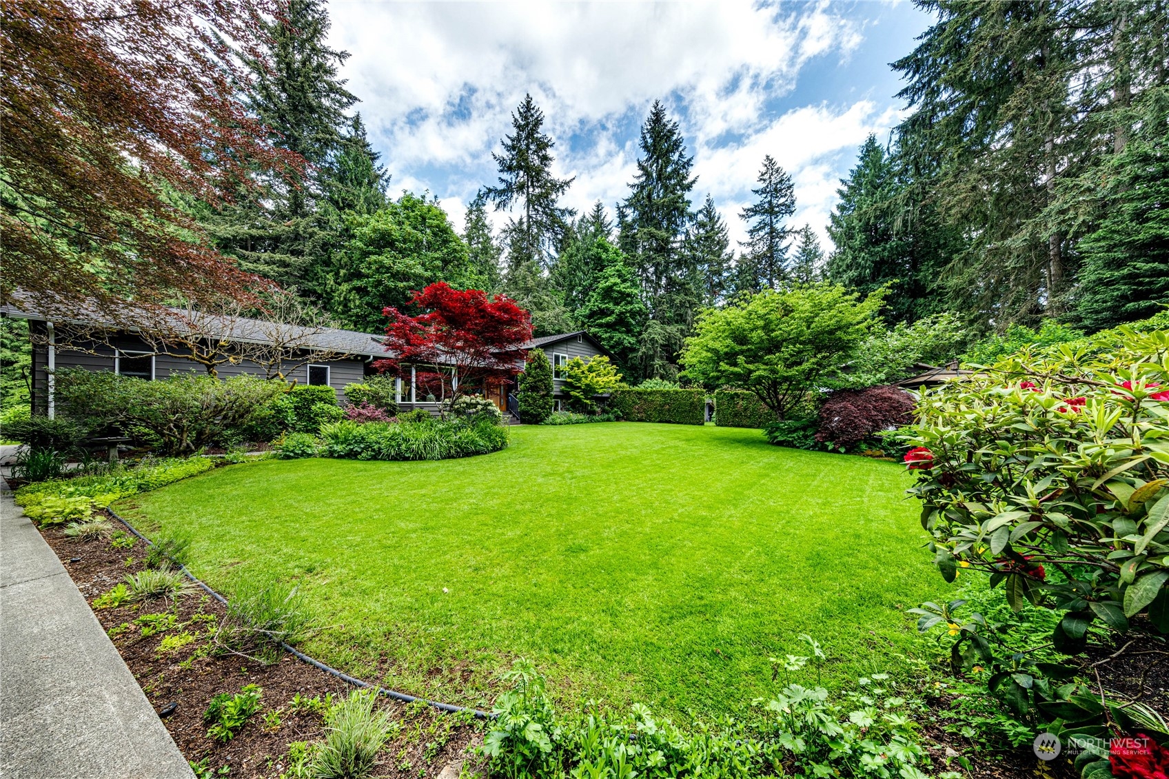 17129 North Road Bothell, WA 98012 - Photo 34 of 40 a view of a garden with a bench in front of the house