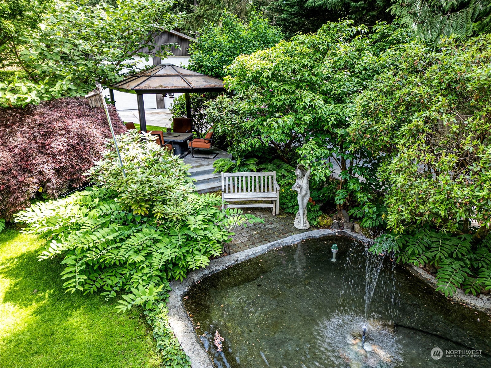 17129 North Road Bothell, WA 98012 - Photo 36 of 40 a view of a garden with a table and chairs under an umbrella