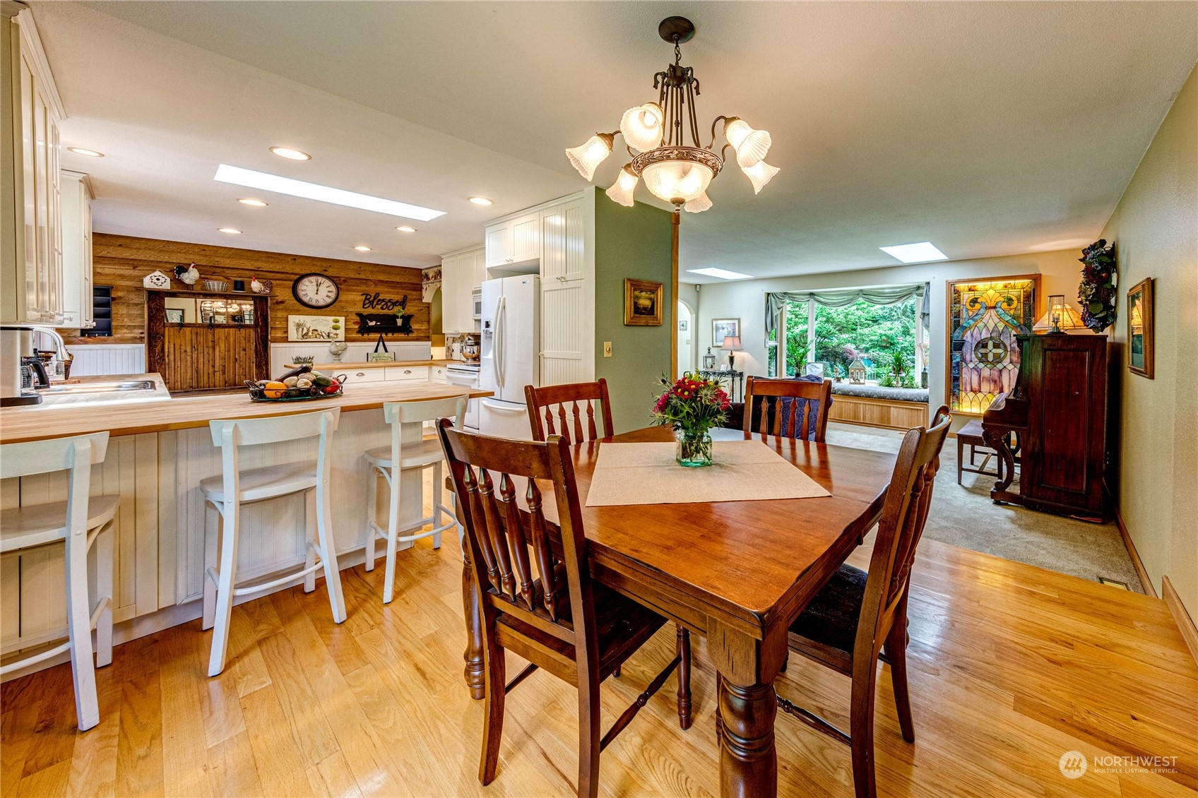 17129 North Road Bothell, WA 98012 - Photo 6 of 40 a dining room with furniture a chandelier and wooden floor