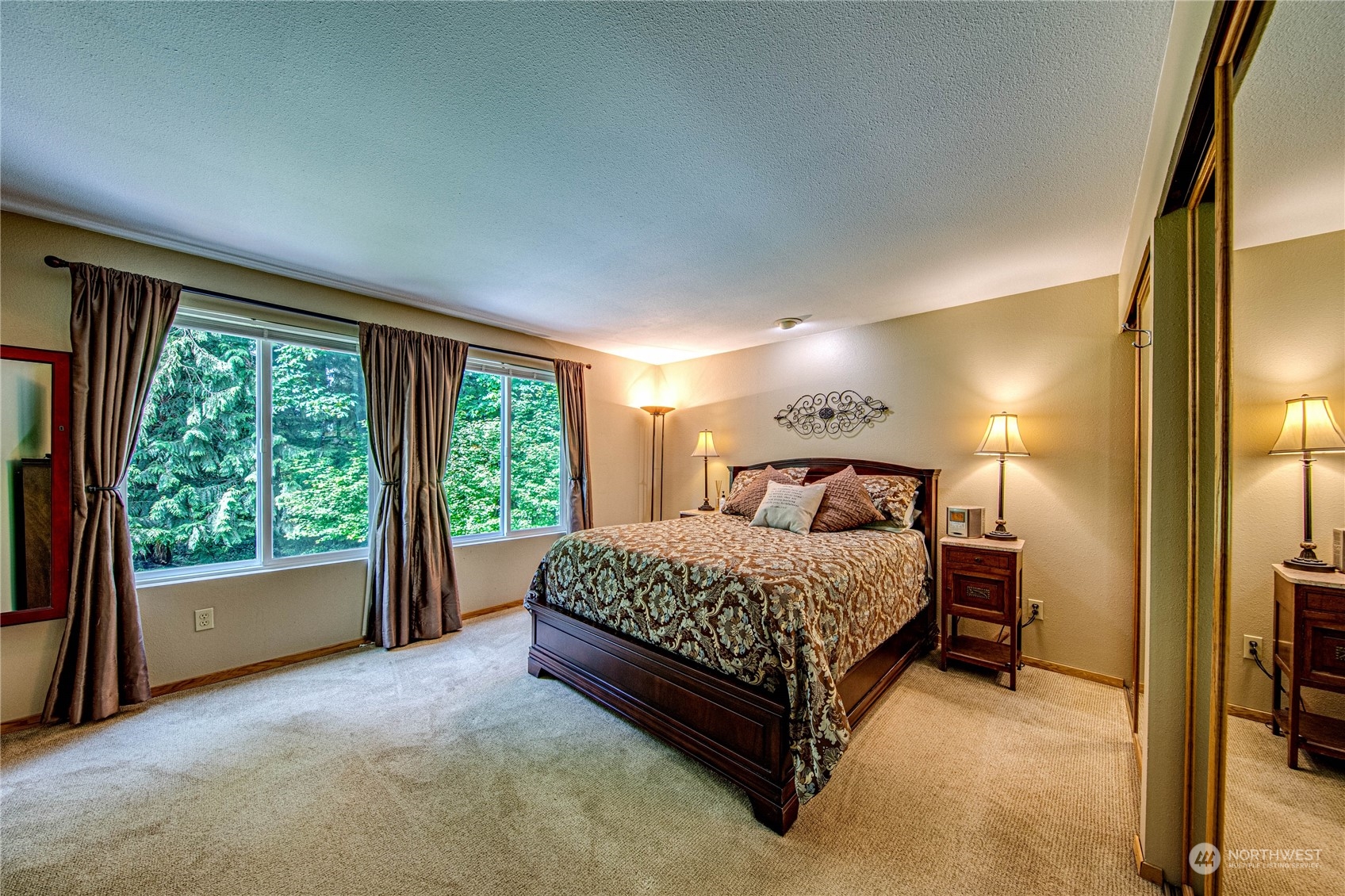 17129 North Road Bothell, WA 98012 - Photo 10 of 40 a spacious bedroom with a bed lamp and window
