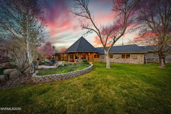 a dining room with stainless steel appliances granite countertop a table chairs and a refrigerator