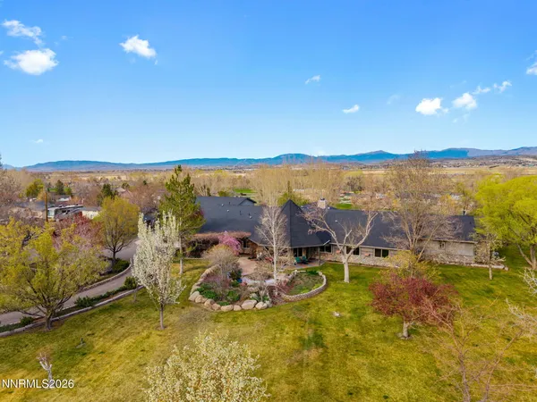 a living room with furniture a fireplace and a dining table with wooden floor