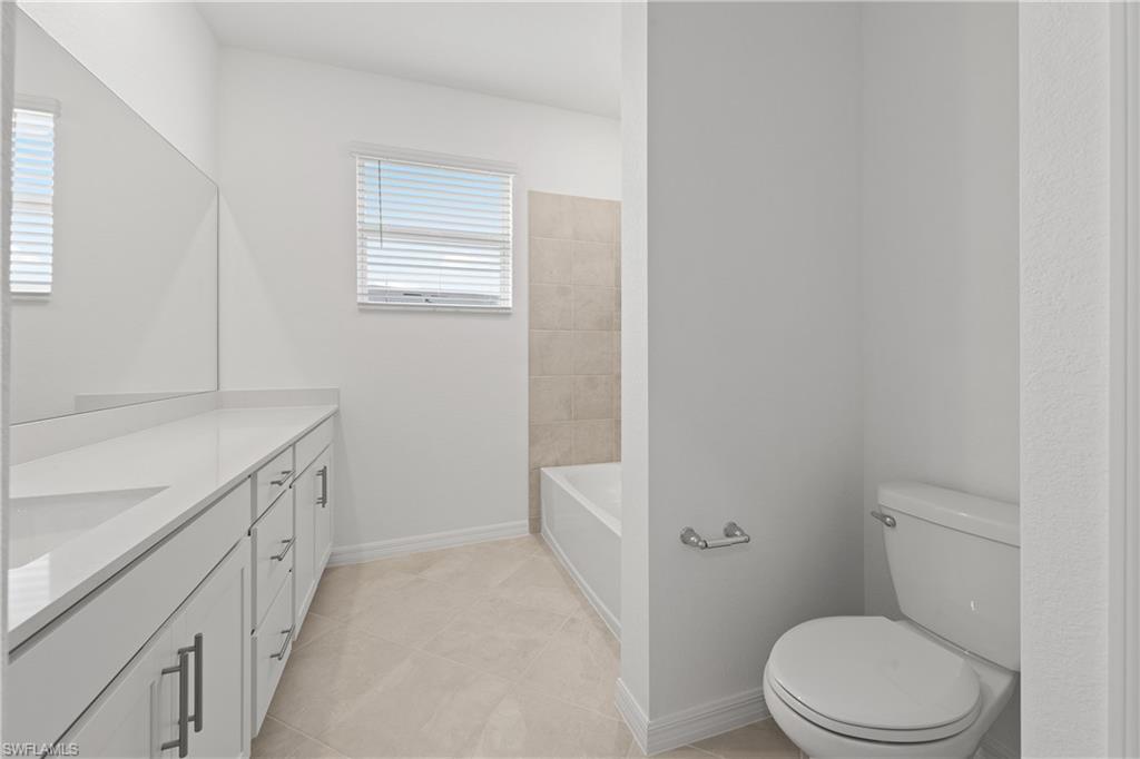 15035 White Pearl Road Babcock Ranch, FL 33982 - Photo 33 of 43 a bathroom with a granite countertop toilet a sink and a bathtub