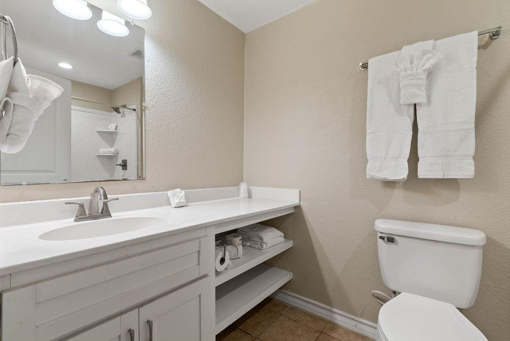 919 North Fulton Beach Road, Unit 324 Fulton, TX 78382 - Photo 7 of 21 a bathroom with a granite countertop toilet sink and mirror
