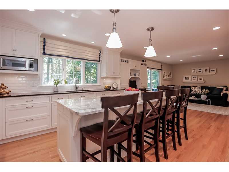 18 Devon Road Darien, CT 06820 - Photo 8 of 25 a kitchen with stainless steel appliances kitchen island granite countertop a table chairs sink and cabinets