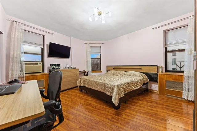 a bedroom with a bed a flat screen tv and dresser