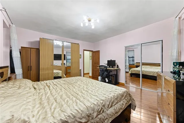 a bedroom with a large bed and wooden floor