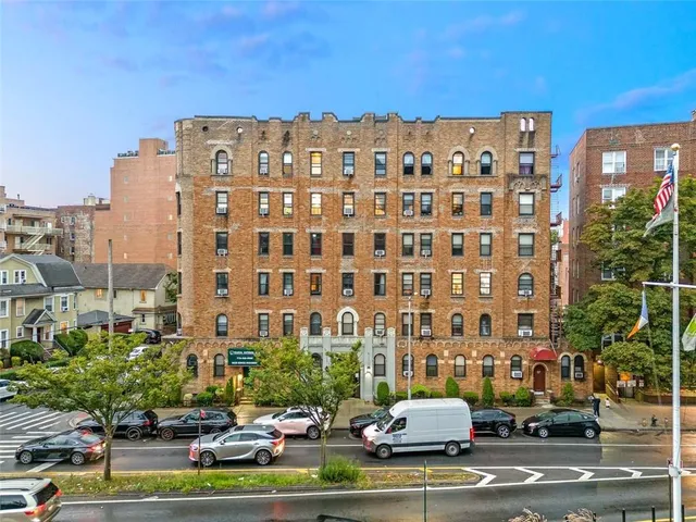 a view of a buildings with cars on city street