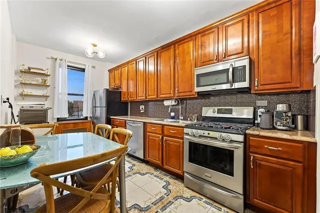 a kitchen with stainless steel appliances granite countertop a stove a sink dishwasher and a microwave oven with cabinets