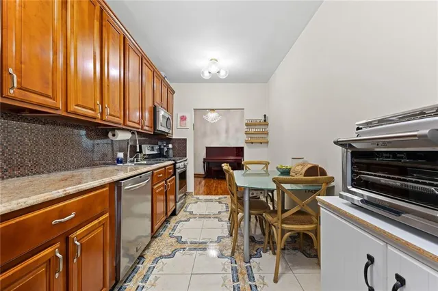a kitchen with stainless steel appliances granite countertop a stove a sink dishwasher and a microwave oven with cabinets