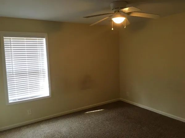 an empty room with a fan and a window