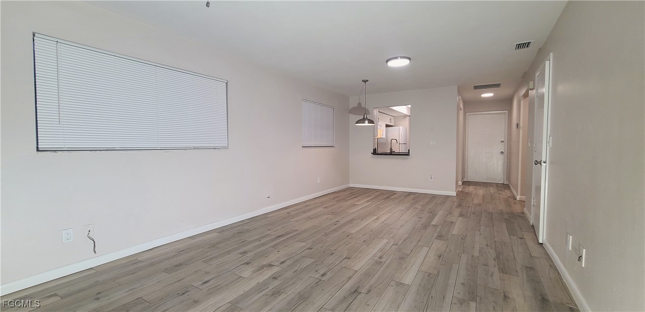 930 Southwest 47th Terrace, Unit 7 Cape Coral, FL 33914 - Photo 11 of 29 a view of a big room with wooden floor and windows