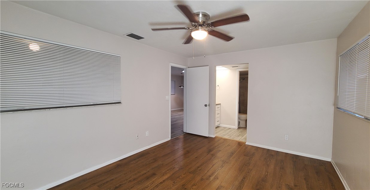 930 Southwest 47th Terrace, Unit 7 Cape Coral, FL 33914 - Photo 18 of 29 an empty room with wooden floor and a ceiling fan