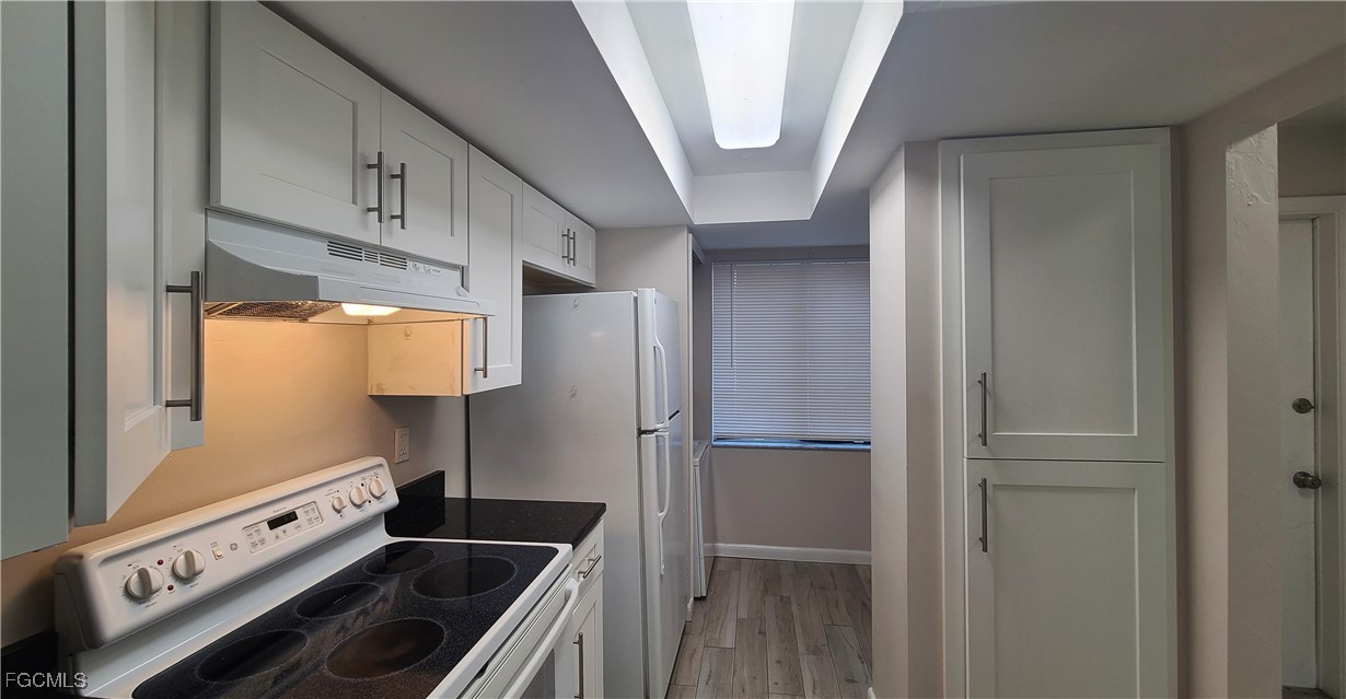 930 Southwest 47th Terrace, Unit 7 Cape Coral, FL 33914 - Photo 5 of 29 a kitchen with a refrigerator and a stove