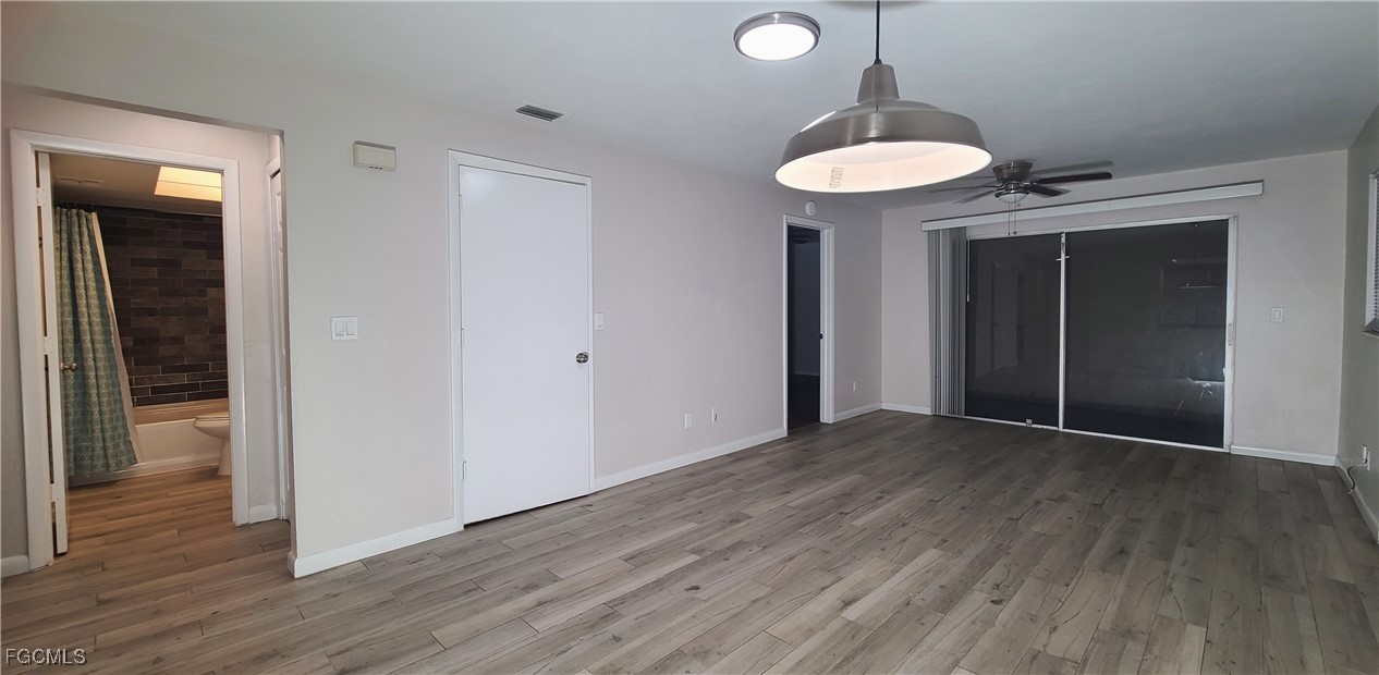 930 Southwest 47th Terrace, Unit 7 Cape Coral, FL 33914 - Photo 10 of 29 a view of a room with wooden floor and a ceiling fan