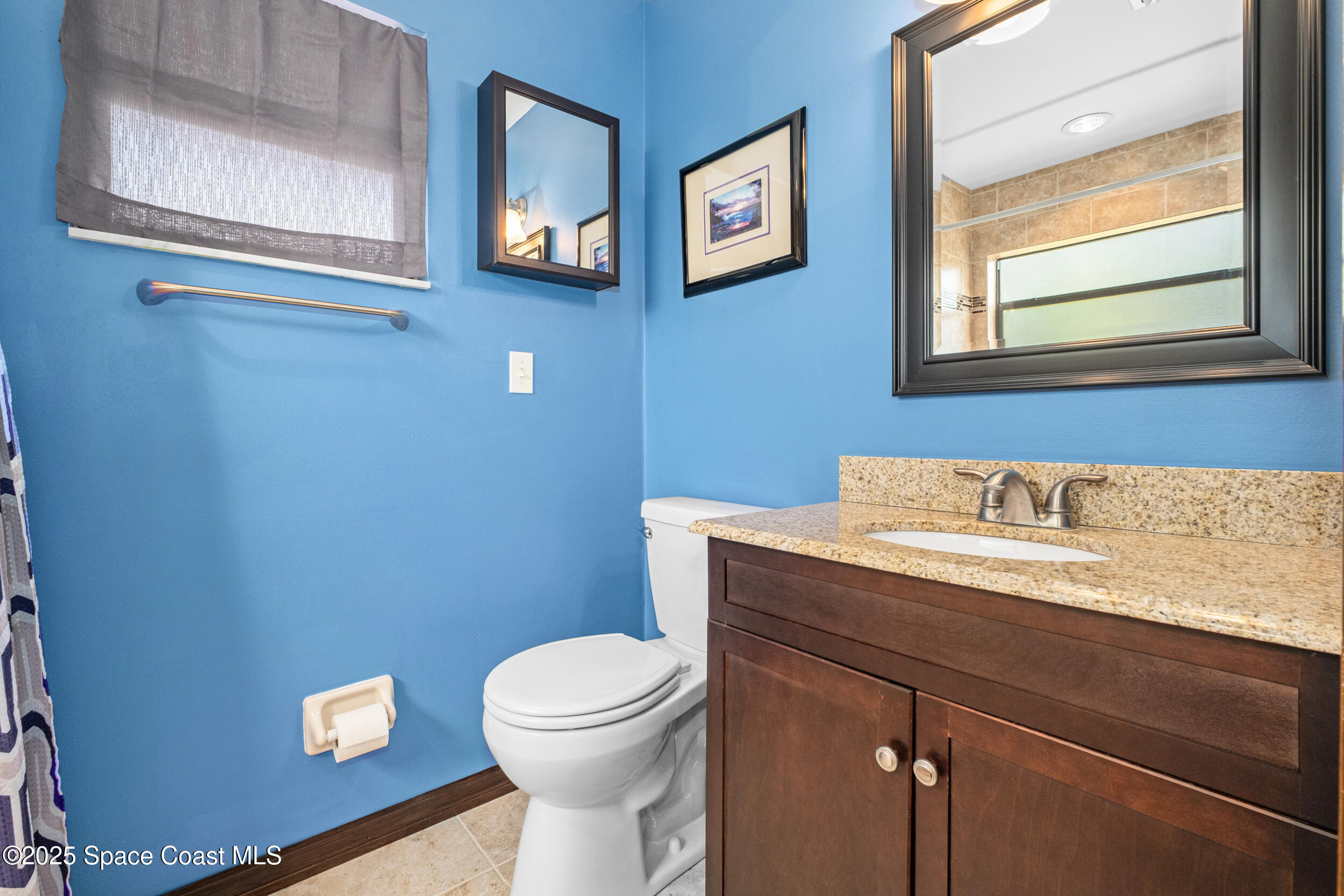1170 Faulkingham Road Merritt Island, FL 32952 - Photo 16 of 31 a bathroom with a toilet a sink and mirror