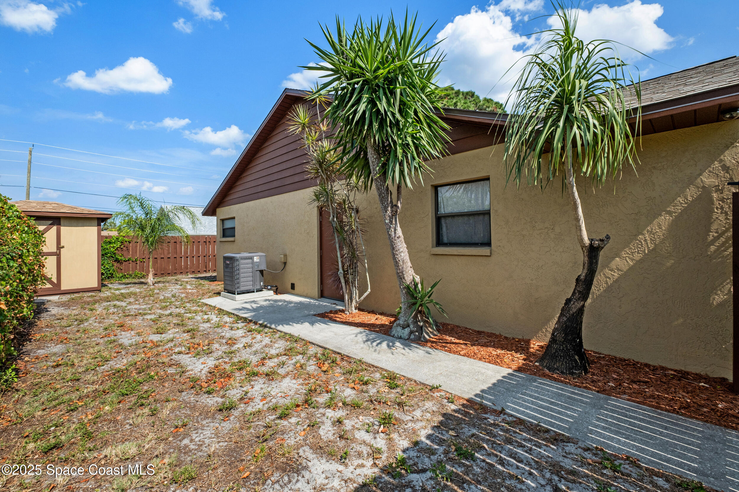 1170 Faulkingham Road Merritt Island, FL 32952 - Photo 24 of 31 a palm plant sitting in front of a house with a potted plant
