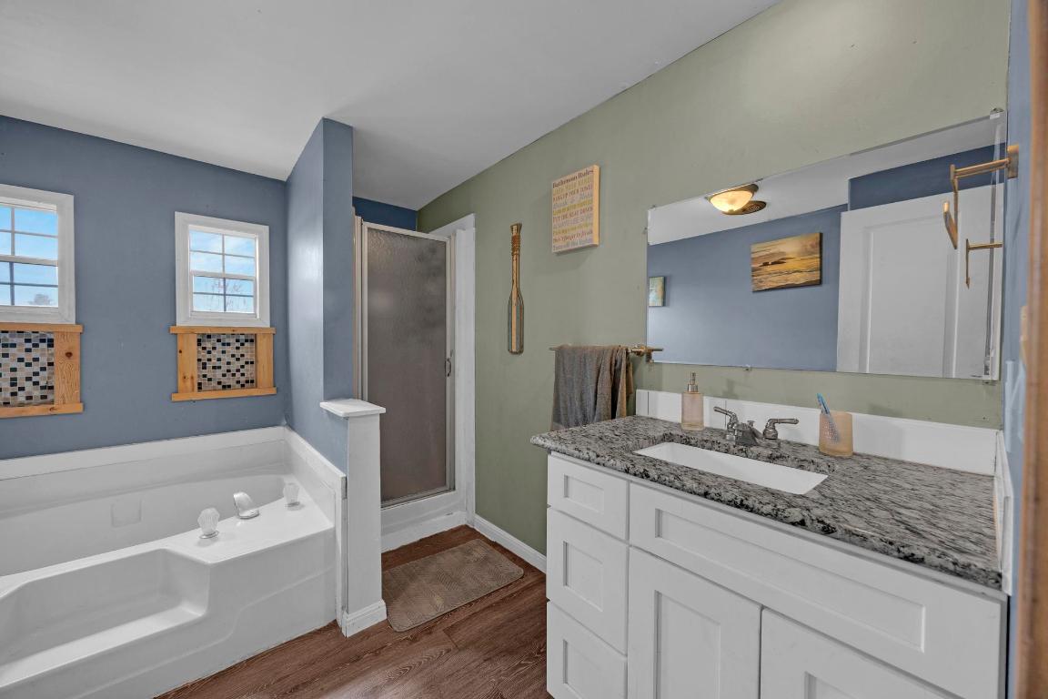 106 Cloudberry Lane Elgin, TX 78621 - Photo 19 of 33 a bathroom with a granite countertop tub sink and mirror