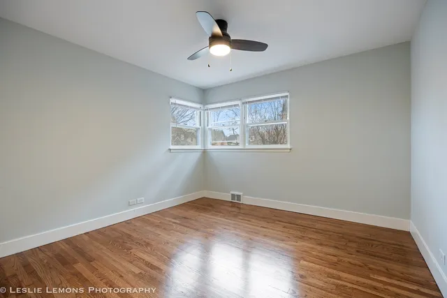 a view of a room with wooden floor and ceiling fan