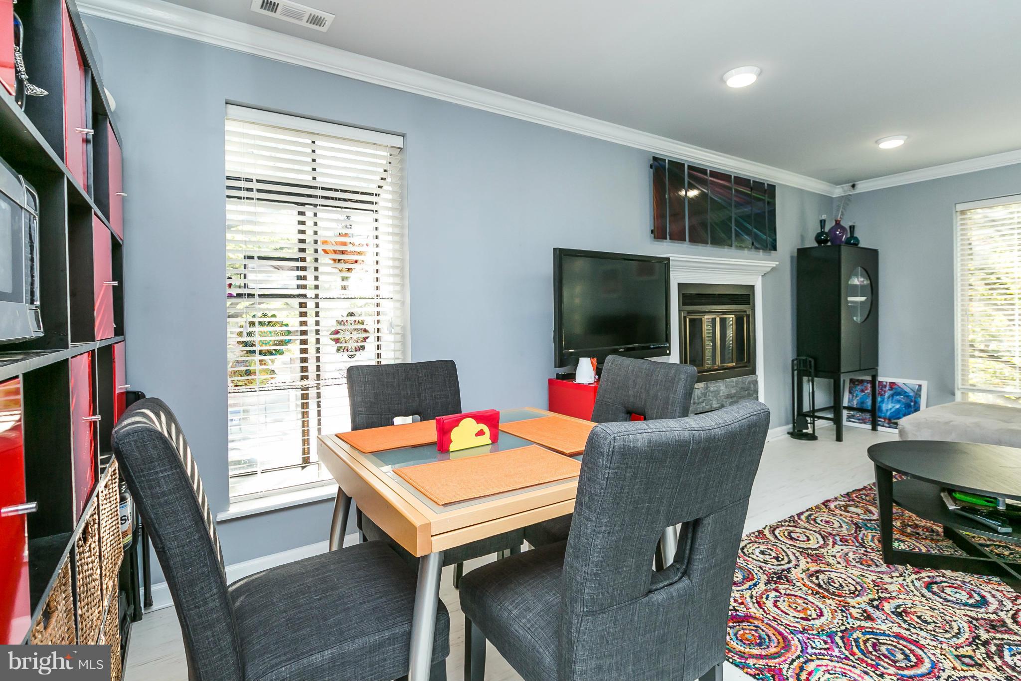 2 West Lee Street, Unit R59 Baltimore, MD 21201 - Photo 8 of 28 a living room with furniture a flat screen tv and a dining table