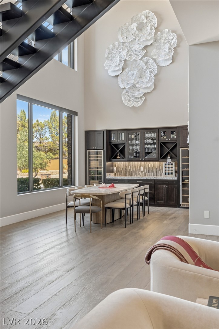 5 Crystal Tree Pass Henderson, NV 89052 - Photo 9 of 67 A spacious dining area featuring a modern built-in bar, high ceilings, and expansive windows for plentiful natural light.