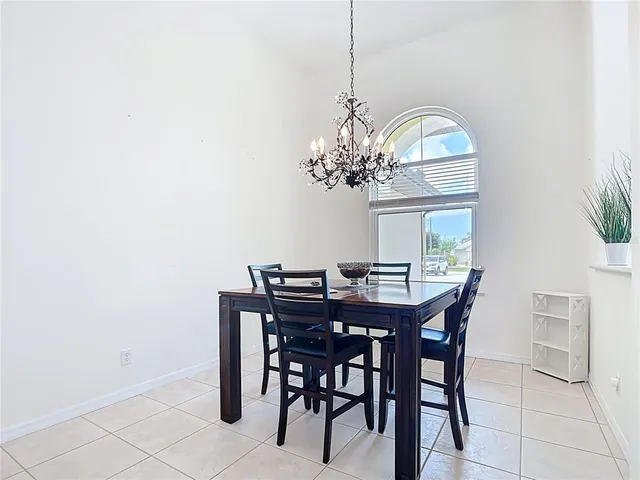 a dining room with furniture a chandelier and window