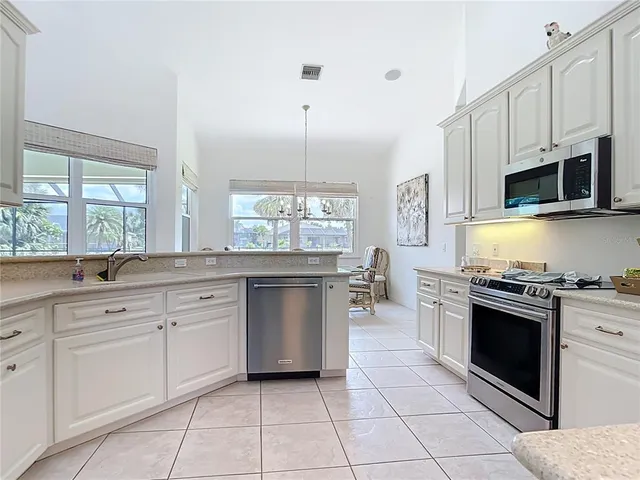 a bed sitting in a bedroom next to a bathroom with a sink and a mirror