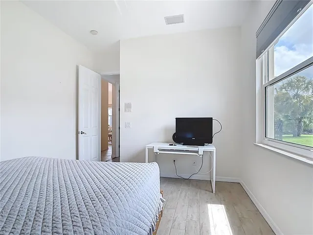 a spacious bedroom with a bed and a television