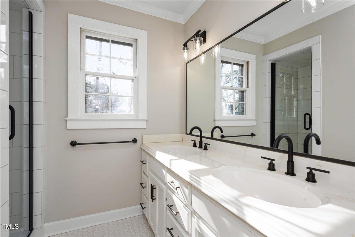 2205 Pastille Lane Raleigh, NC 27612 - Photo 13 of 31 a bathroom with double vanity sink a mirror and a shower