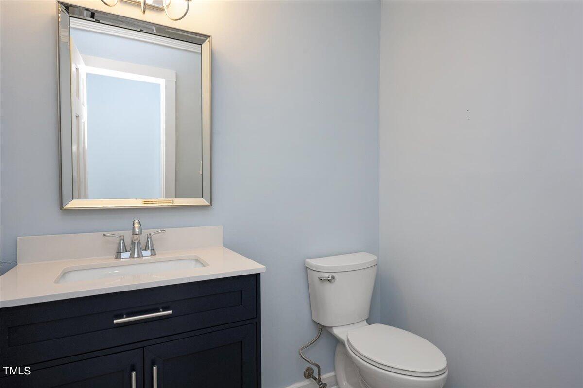 2205 Pastille Lane Raleigh, NC 27612 - Photo 18 of 31 a bathroom with a toilet a sink and mirror