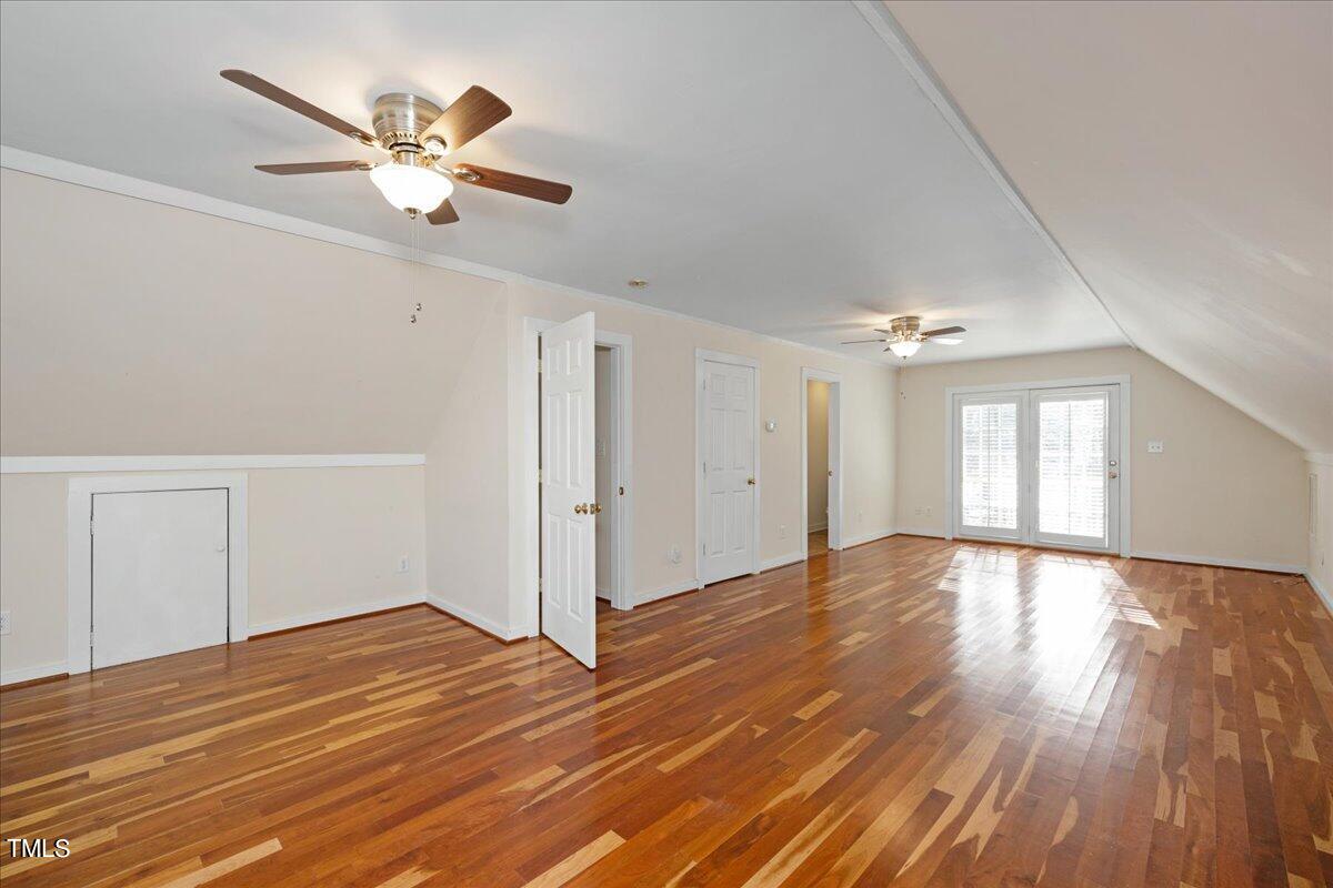2205 Pastille Lane Raleigh, NC 27612 - Photo 19 of 31 an empty room with wooden floor chandelier fan and windows