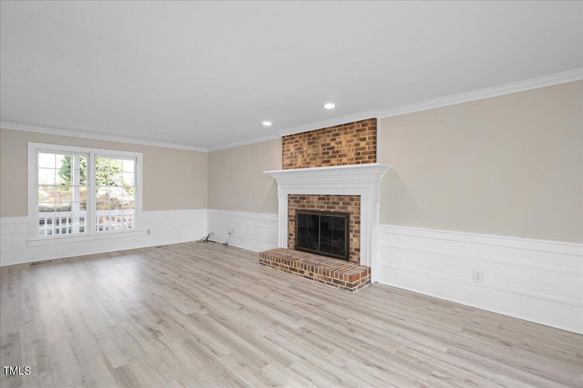 2205 Pastille Lane Raleigh, NC 27612 - Photo 4 of 31 a view of empty room with wooden floor and fireplace