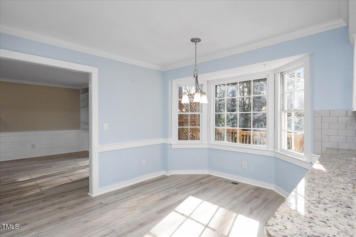 2205 Pastille Lane Raleigh, NC 27612 - Photo 5 of 31 a view of an empty room with a window and wooden floor