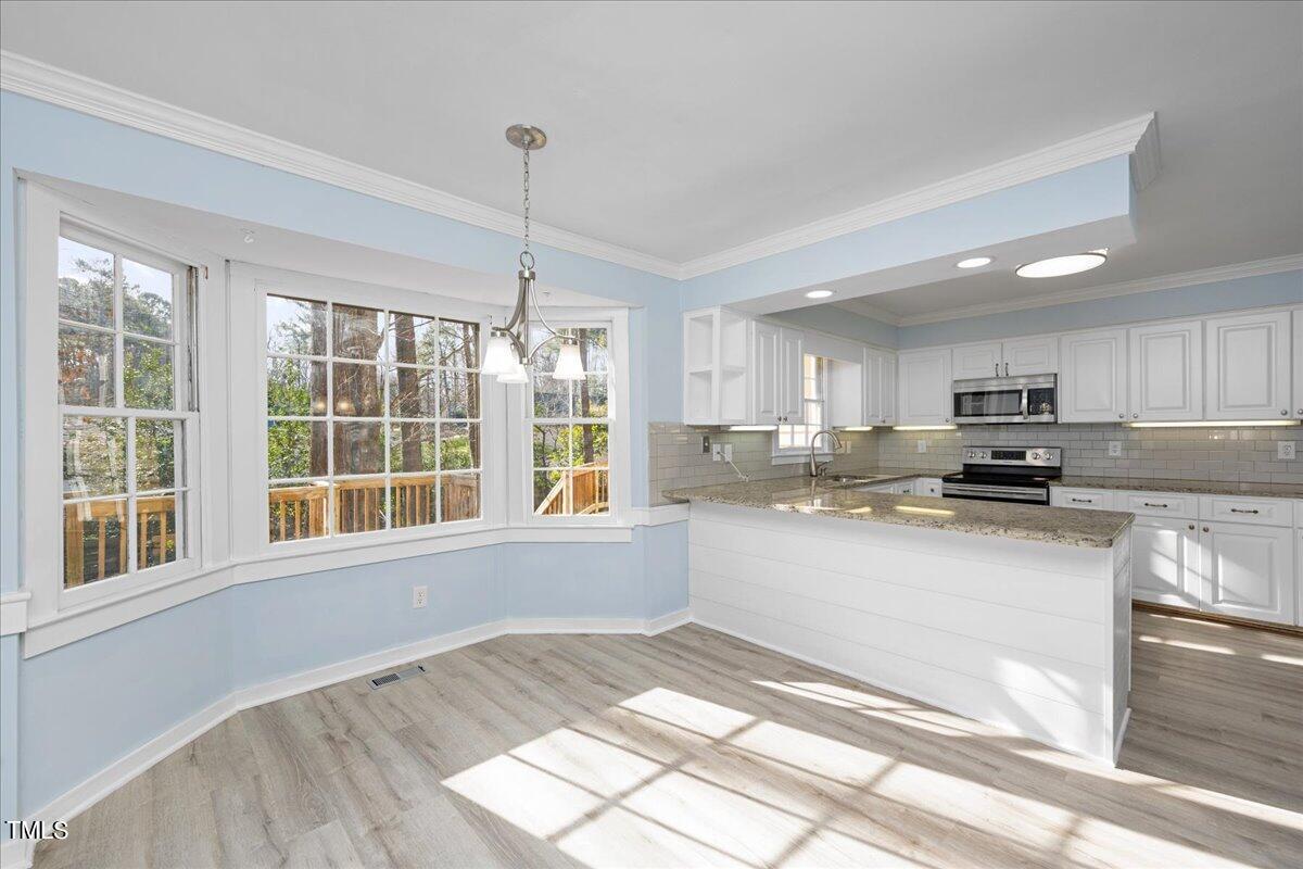 2205 Pastille Lane Raleigh, NC 27612 - Photo 6 of 31 a kitchen with stainless steel appliances granite countertop a stove a sink and a refrigerator