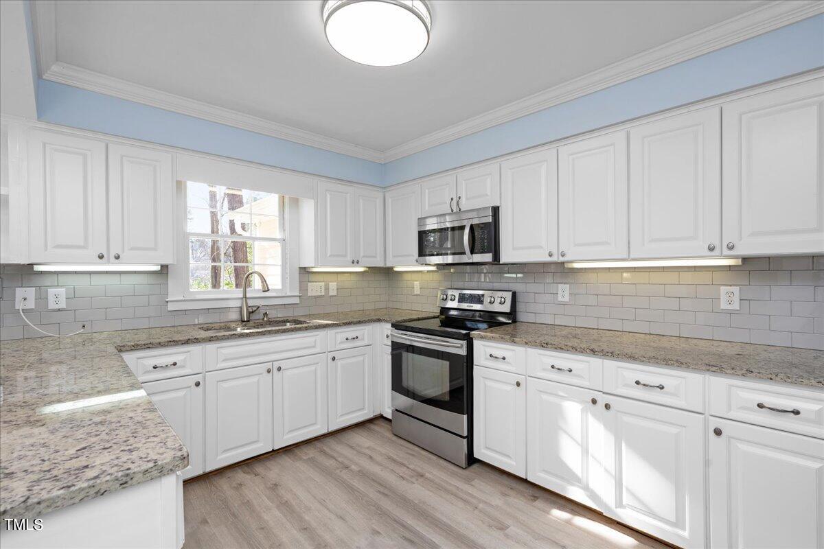 2205 Pastille Lane Raleigh, NC 27612 - Photo 7 of 31 a kitchen with cabinets appliances a sink and a window