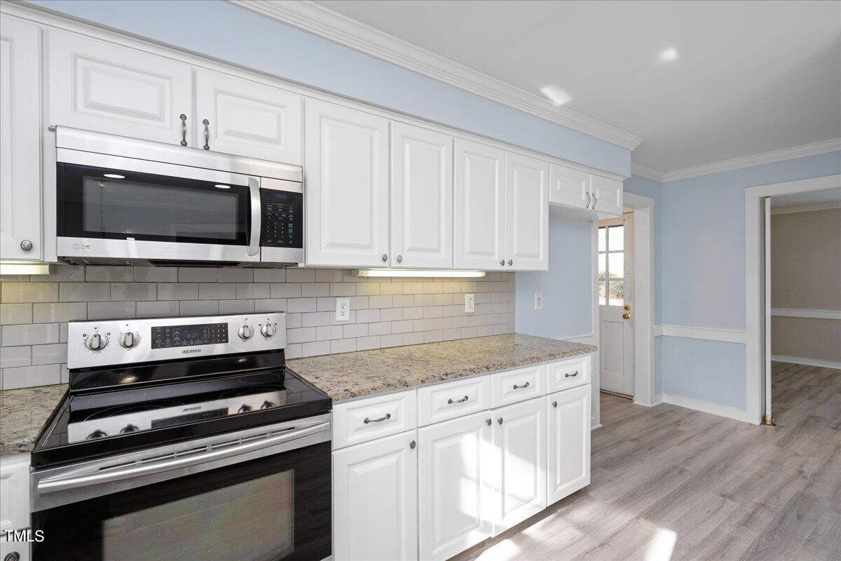 2205 Pastille Lane Raleigh, NC 27612 - Photo 9 of 31 a kitchen with cabinets stainless steel appliances and wooden floor