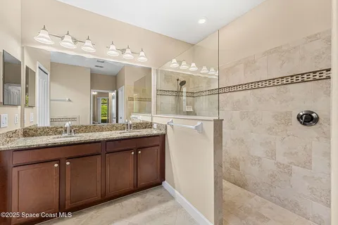 a bathroom with a tub a double vanity sink and a large mirror