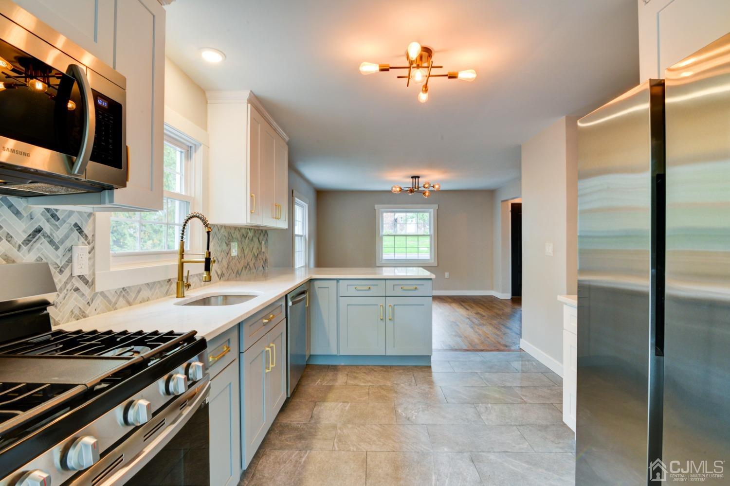 420 Chain O' Hills Road Colonia, NJ 07067 - Photo 14 of 37 a kitchen with a stove a sink and a refrigerator