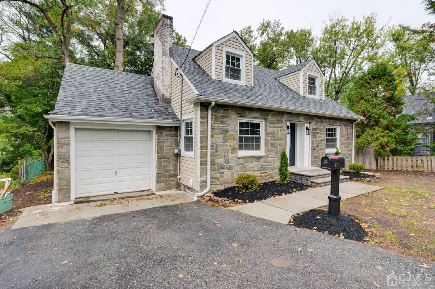 420 Chain O' Hills Road Colonia, NJ 07067 - Photo 2 of 37 a front view of a house with a yard and garage